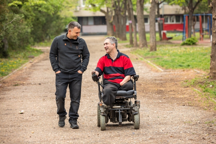 Male walking alongside wheelchair user.jpg